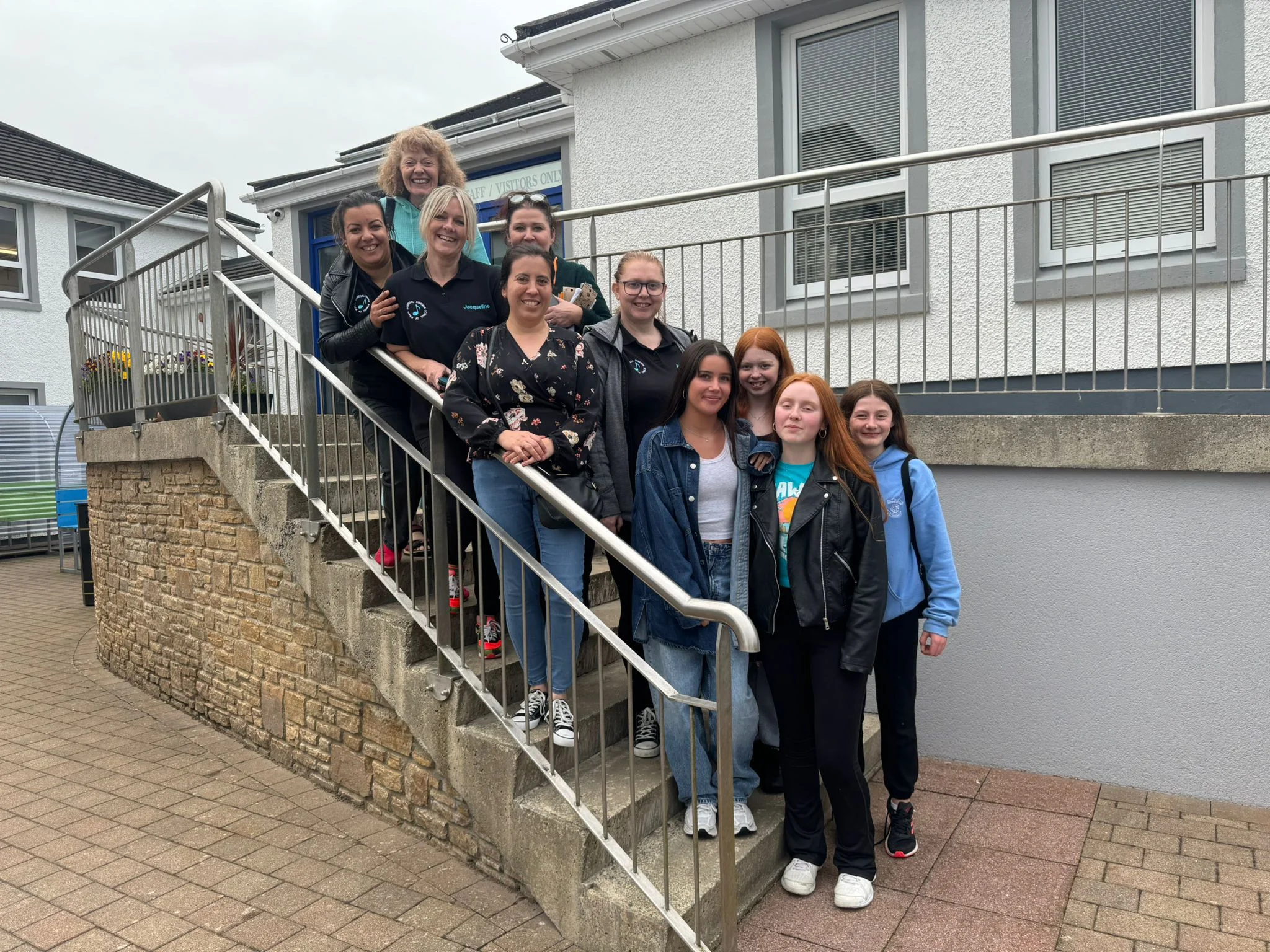 Group of volunteers and students on the steps outside